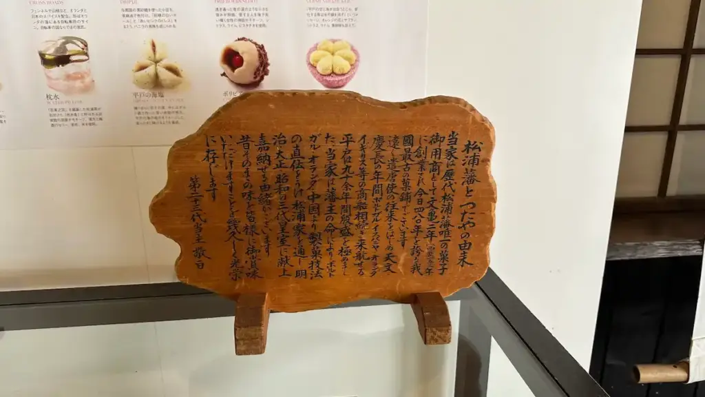 長崎県平戸市の按針の館に展示されている和菓子の由来を説明する木製の案内板。背後に和菓子の写真と解説が並んでいる
