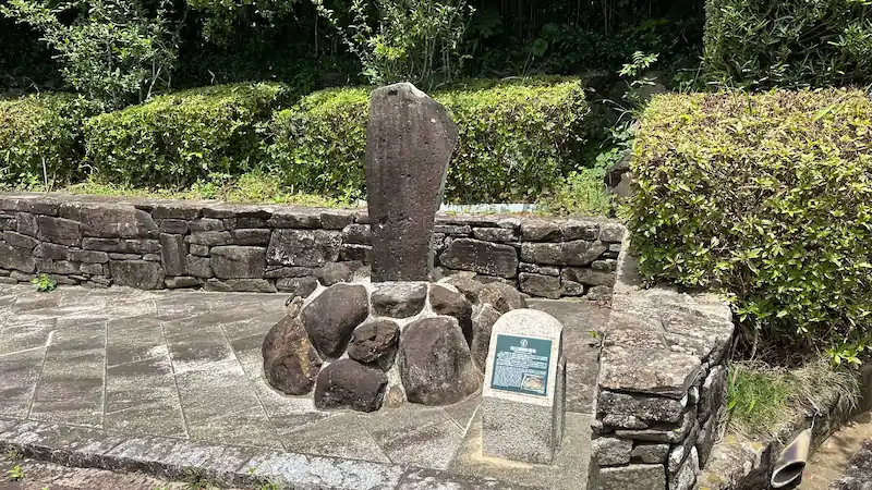 長崎県平戸市の三浦按針墓所にある三浦家の古い墓石。石垣と植え込みに囲まれた歴史的な墓標