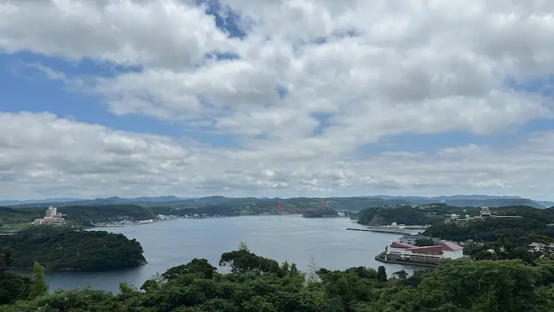 展望台から見た平戸港と周辺の風景。海に囲まれた町並みと遠くの山並みが広がる眺望