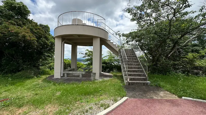 アンジンローズガーデン近くの小さな展望台。白い鉄製の階段と丸い屋根が特徴で周囲に緑が広がる