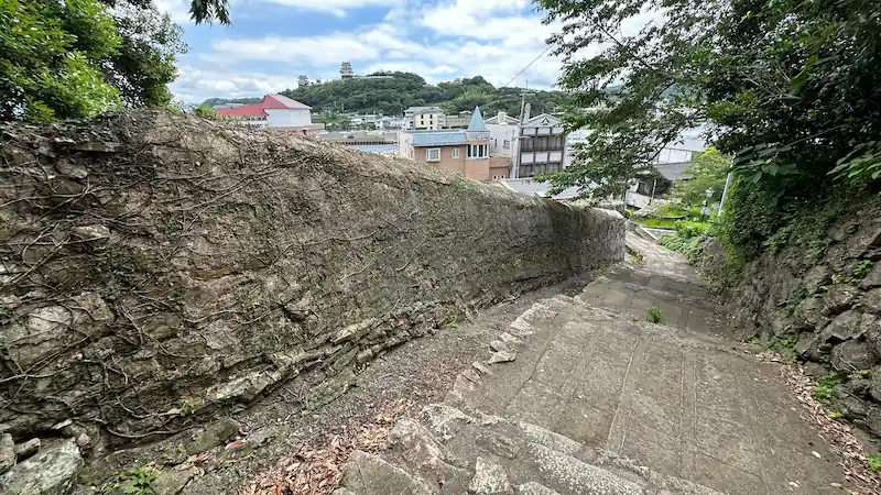 長崎県平戸市のオランダ塀沿いの石段を上から見下ろした風景。奥に平戸城や市街地が広がる歴史的な坂道