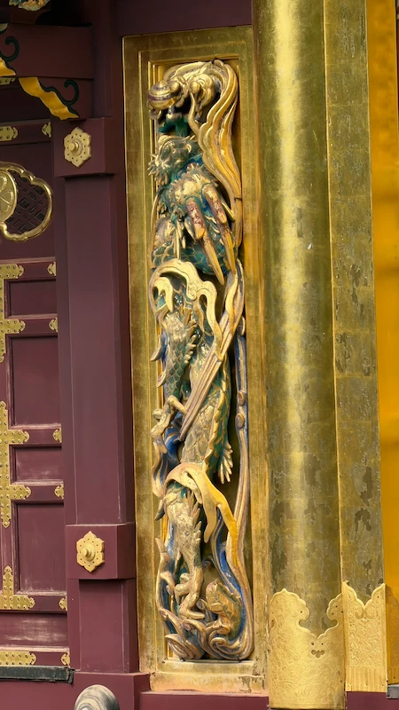 Dragon carving on the Karamon Gate at Ueno Toshogu Shrine. A wooden carving with blue-green and gold colors intertwined.