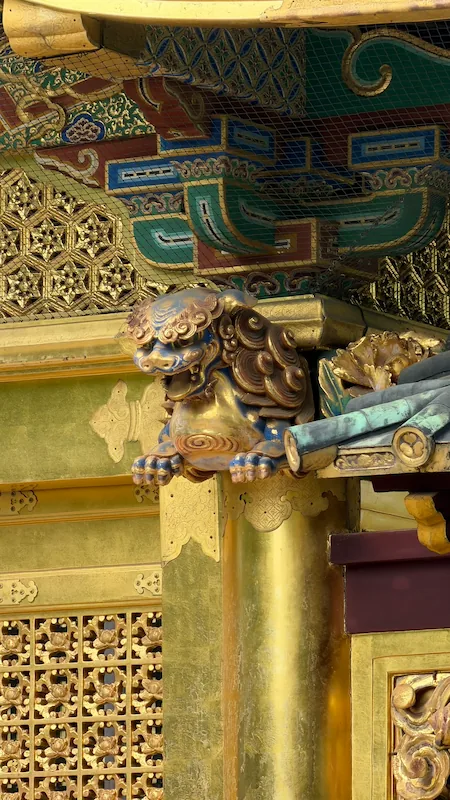 Golden shigami lion carving above a pillar at Ueno Toshogu Shrine’s Kinshikiden.