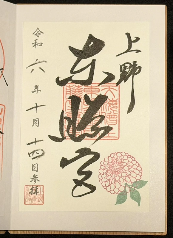 Standard goshuin of Ueno Toshogu, dated October 2024, featuring hand-brushed calligraphy and a dahlia illustration in pink and green