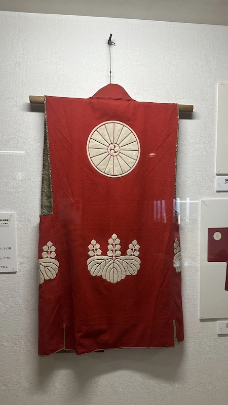 豊臣家の家紋（菊・五三の桐）がついた赤い陣羽織——和歌山城天守閣内展示