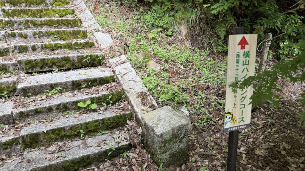 The sign for the Saigoku Thirty-Three Kannon Pilgrimage Route beneath the trees at Kannonji Temple