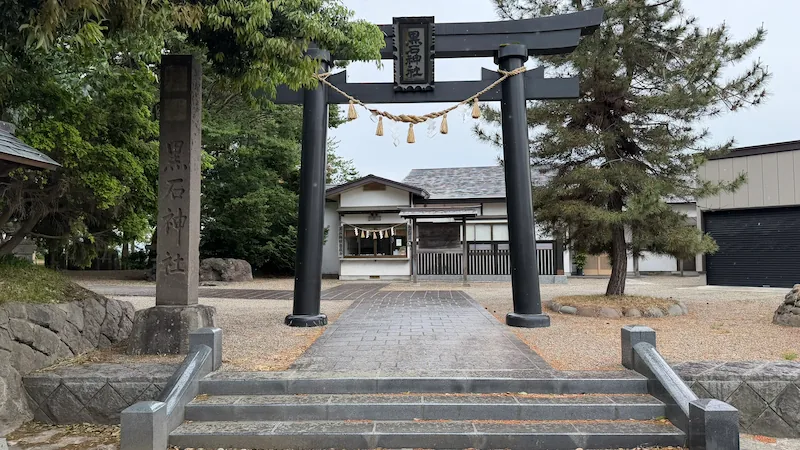 The juyo-sho reception area at Kuroishi Shrine, visible beyond the torii gate