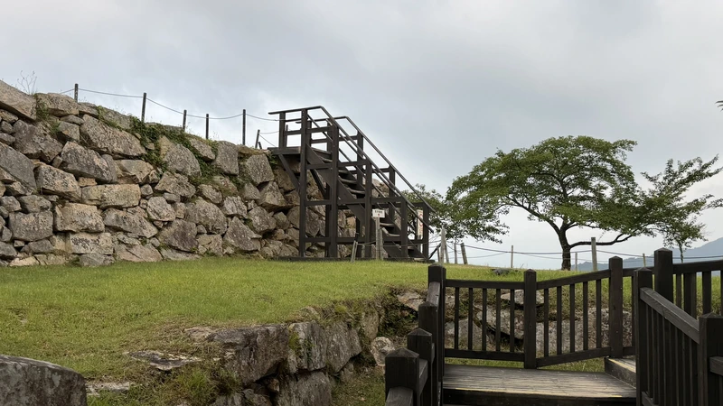 Tenshudai's stone walls and wooden steps, seen from Honmaru — a view that symbolizes the heart of Takeda Castle Ruins.