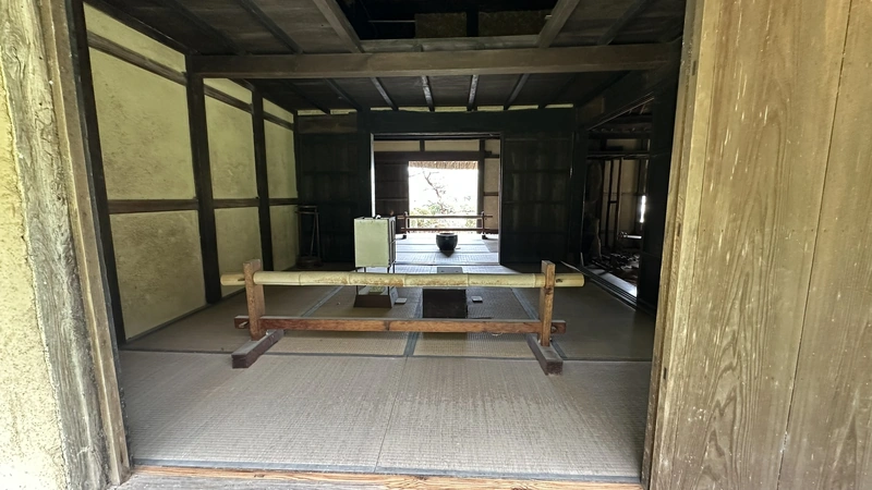 A view through the interior of the Former Miyaji Residence from the entrance, with an earthen-floor passage leading to a hearth and tatami rooms.