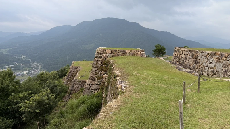 The long, narrow bailey of Minami-Ninomaru and its stone walls, with mountains behind, showing the shape of the castle grounds along the ridge.