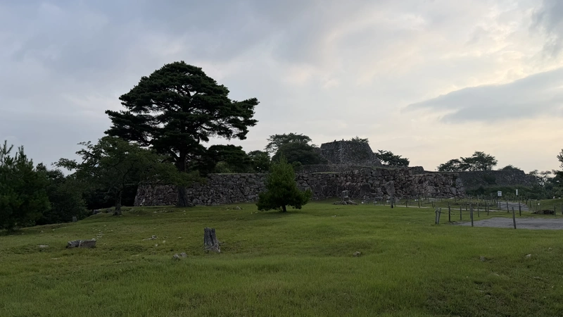 A wide view of the lawn and stone walls at Minami-Senjo, showing the open scenery on the south side of Takeda Castle Ruins.