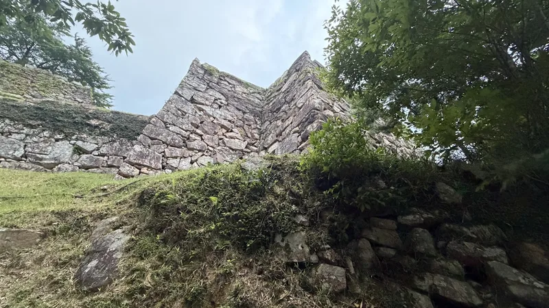 A stone wall near Mitsuke Turret Site, seen looking up from below. The stacking of the corner and its height are visible up close.