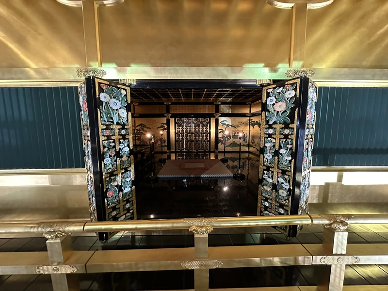 A view down into the interior of the reconstructed upper floor, with carved floral fittings, black lacquer, and a gold-leaf ceiling.