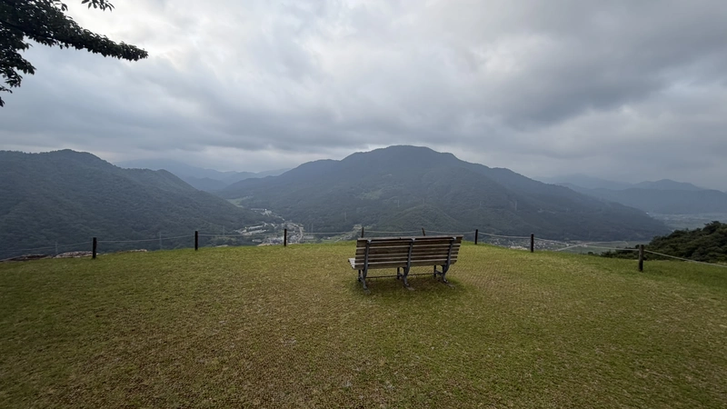 The wide lawn and a bench at Sannomaru, with distant mountains, showing the open, scenic feel of this bailey.