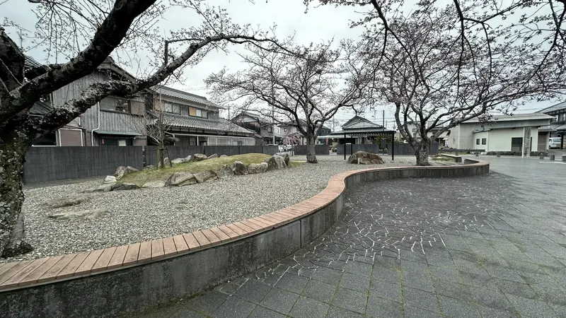 A general view of the Seminario Historic Site Park, with cherry trees, stonework, curved benches, and a garden path.