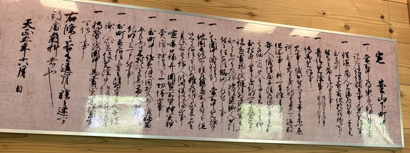 A replica of a document related to Oda Nobunaga on display at Jonavikan. Rows of brushed calligraphy run across the wide horizontal scroll.