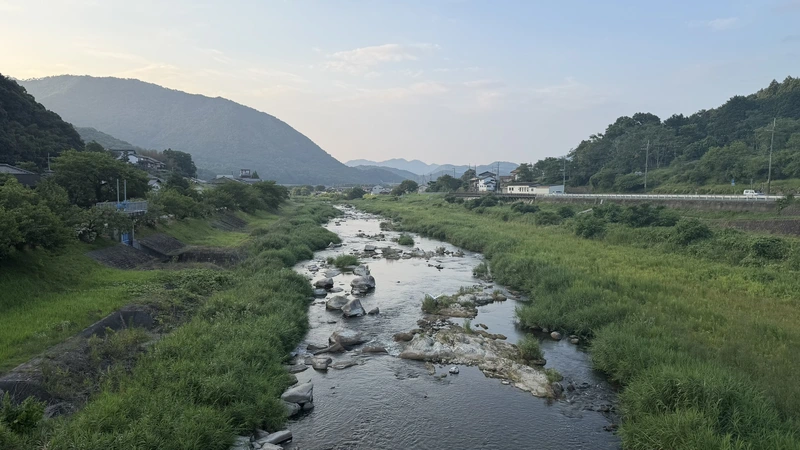 The river running through the Takeda valley, the settlement beside it, and the mountains around — the castle town's setting, seen from ground level.