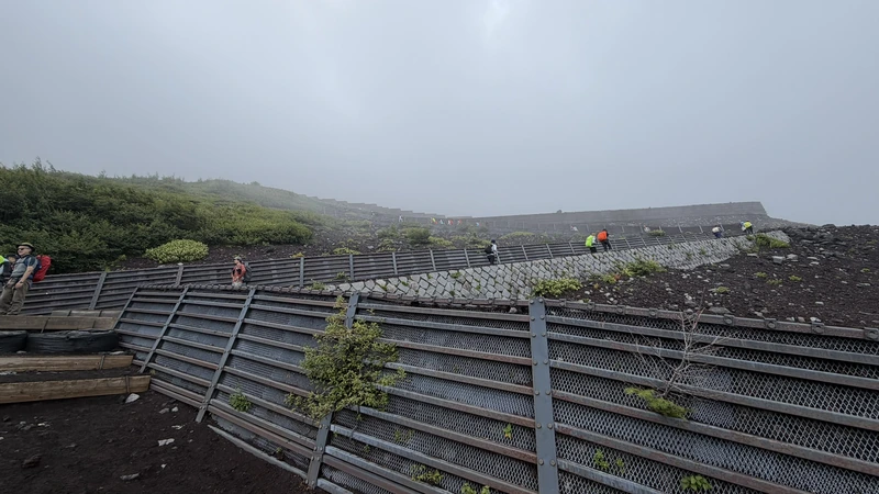 霧の中をジグザグに登る登山者
