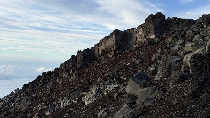 お鉢巡りの急峻な火口壁と登山者