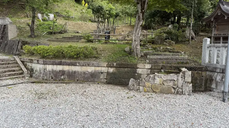 A stone wall and steps, surrounded by trees