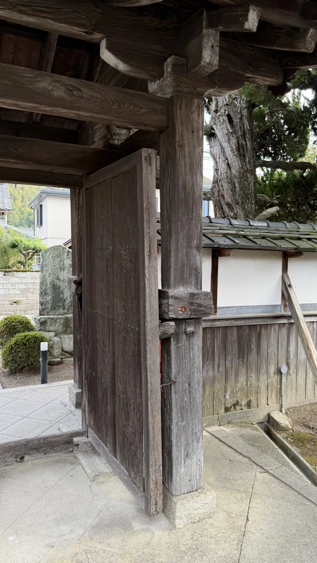 Chokoji Temple's gate as seen from inside the grounds, showing the wooden doors and the gate's structure up close.