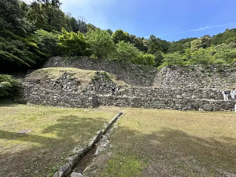 A full view of the residence ruins traditionally attributed to Hideyoshi, seen from Otemichi, showing the upper and lower terraces and stone walls.