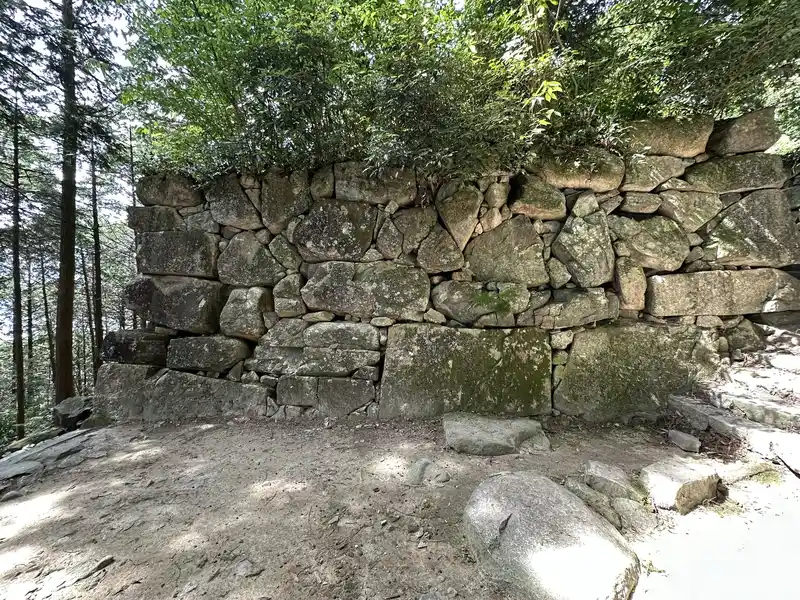 The tall stone wall surviving at Kuroganemon Gate, viewed head-on. It combines large and small stones.