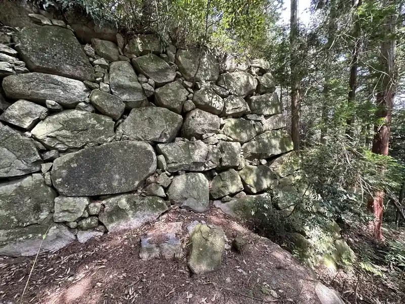 The base of the Kuroganemon Gate stone wall, with a small stone object placed in front of a large stone.