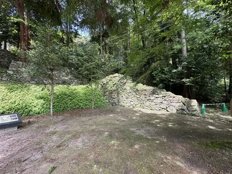 The flat terrace at the residence ruins traditionally attributed to Maeda Toshiie, with a passage-like opening visible in the stone wall on the right.
