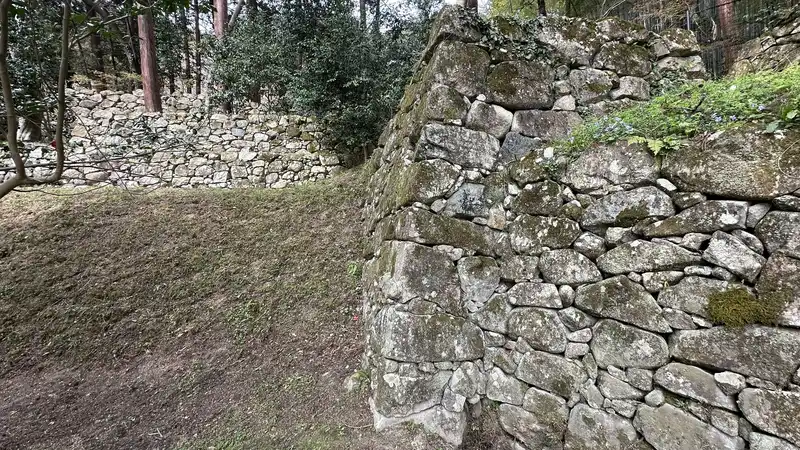 A corner of stone wall at the residence ruins traditionally attributed to Maeda Toshiie, where several sections of wall divide the terraced enclosures.