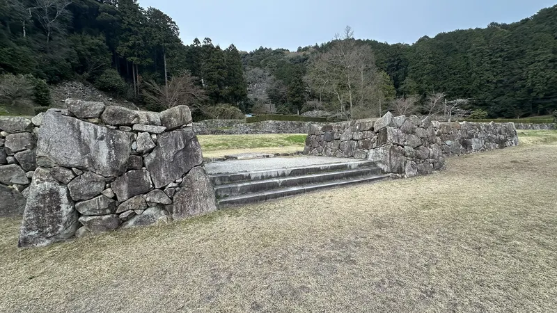 Azuchi Castle's masugata koguchi (box-shaped gate enclosure), surrounded by stone walls, with a central stone stairway leading to the enclosure beyond.