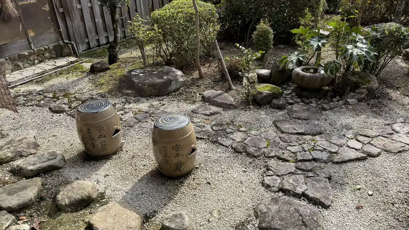Tea ceremony utensils set out in Sokenji's garden, with a stone water basin and garden stones nearby.