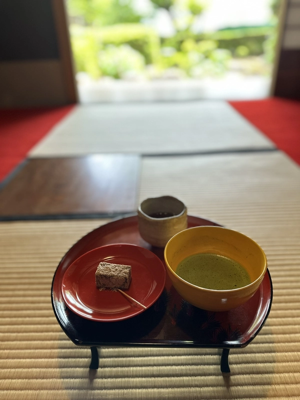 Matcha tea and a traditional Japanese sweet served on a red lacquered tray at Sokenji's tea room.