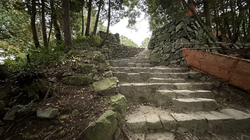 Stone steps rising between stone walls toward the Azuchi Castle Tenshudai, with a flat area visible above.