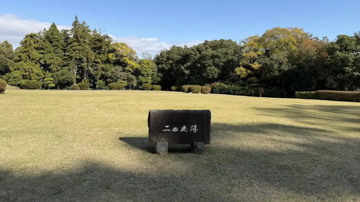 Stone marker for the second enclosure standing on a lawn