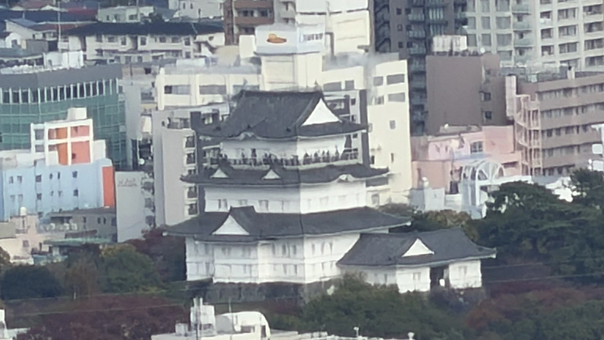 The keep of Odawara Castle picked out among the buildings of the town below