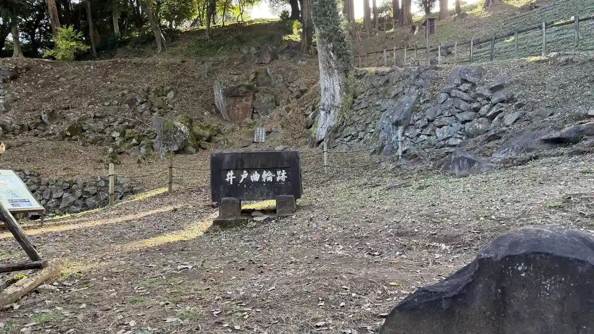 Stone walling enclosing the ravine beyond the marker for the well enclosure
