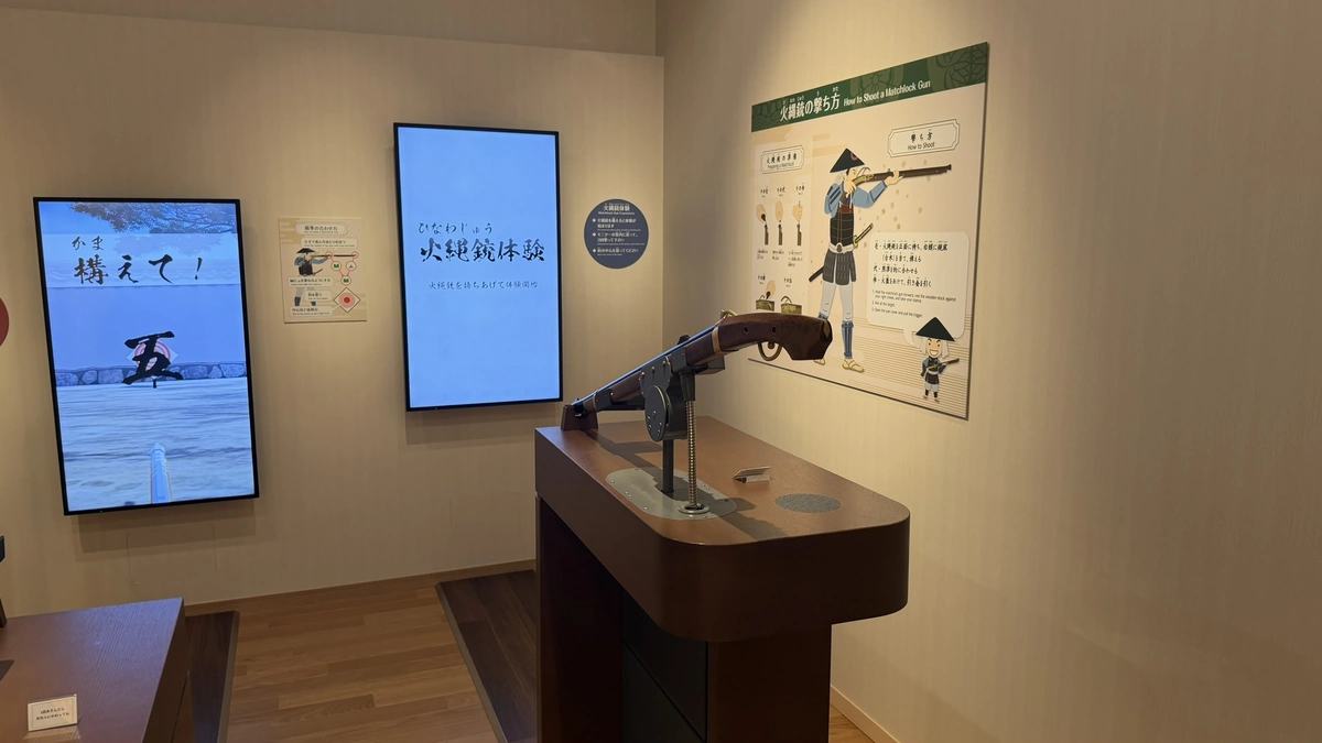 Hands-on display combining a replica matchlock gun with a screen