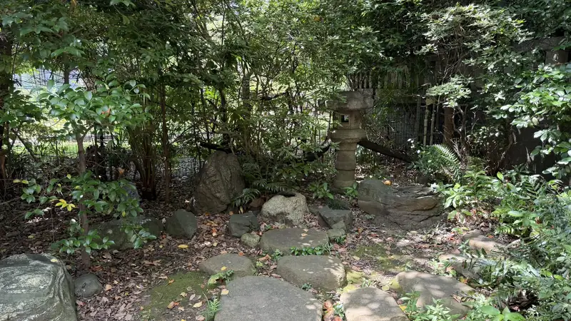 Stone arrangement among plants and a stone lantern in the Shiba Toshogu grounds