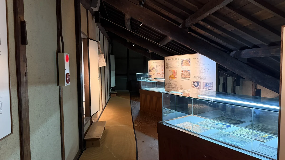 Display cases arranged beneath heavy beams in the former Ishibashi residence