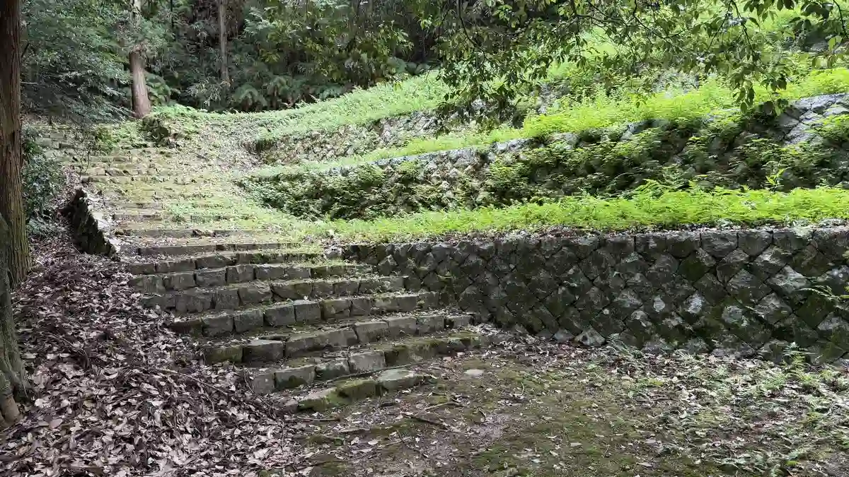 石積みで縁取られた幅のある石段が、草の生えた斜面を社殿へ向かって上っています。