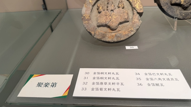 「聚楽第」のラベルと金箔瓦の品名が並ぶ展示ケース内