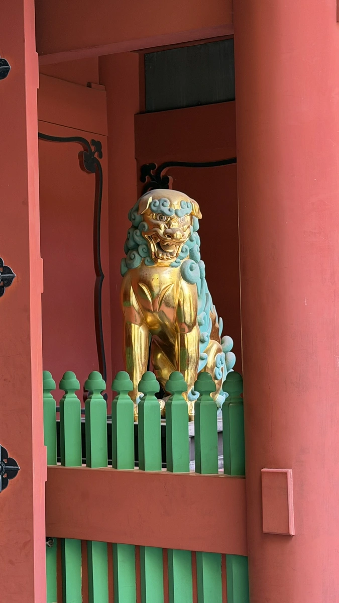 A gold lion figure set into a side bay of the Romon gate at Kunozan Toshogu