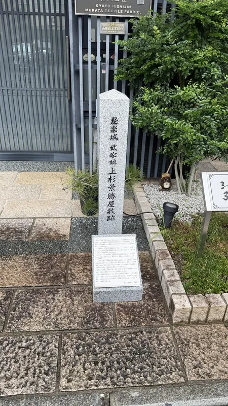 「聚楽城 武家地 上杉景勝屋敷跡」と刻まれた石標。織物工場の門前に立つ