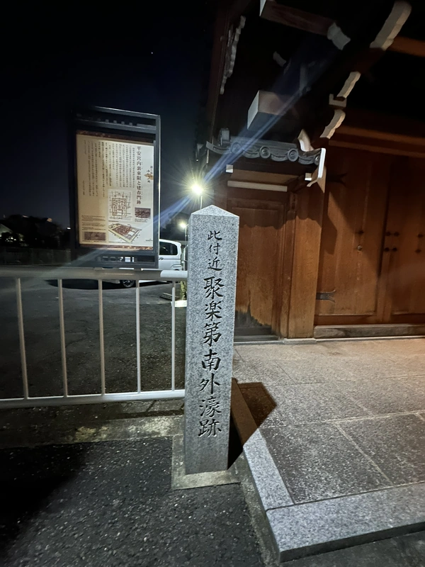 夜間に撮影した聚楽第南外濠跡の石標と松林寺の門