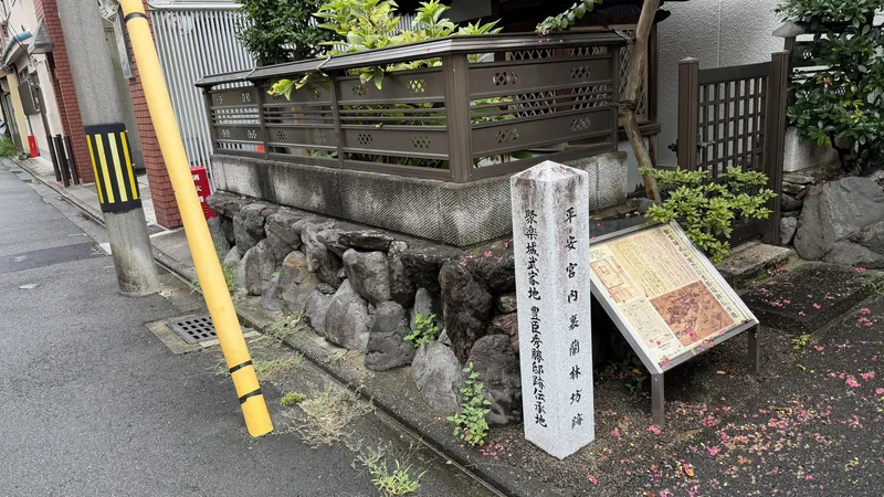 石積みの上に立つ石標。正面に「平安宮内裏蘭林坊跡」、側面に「聚楽城武家地 豊臣秀勝邸跡伝承地」と刻まれる
