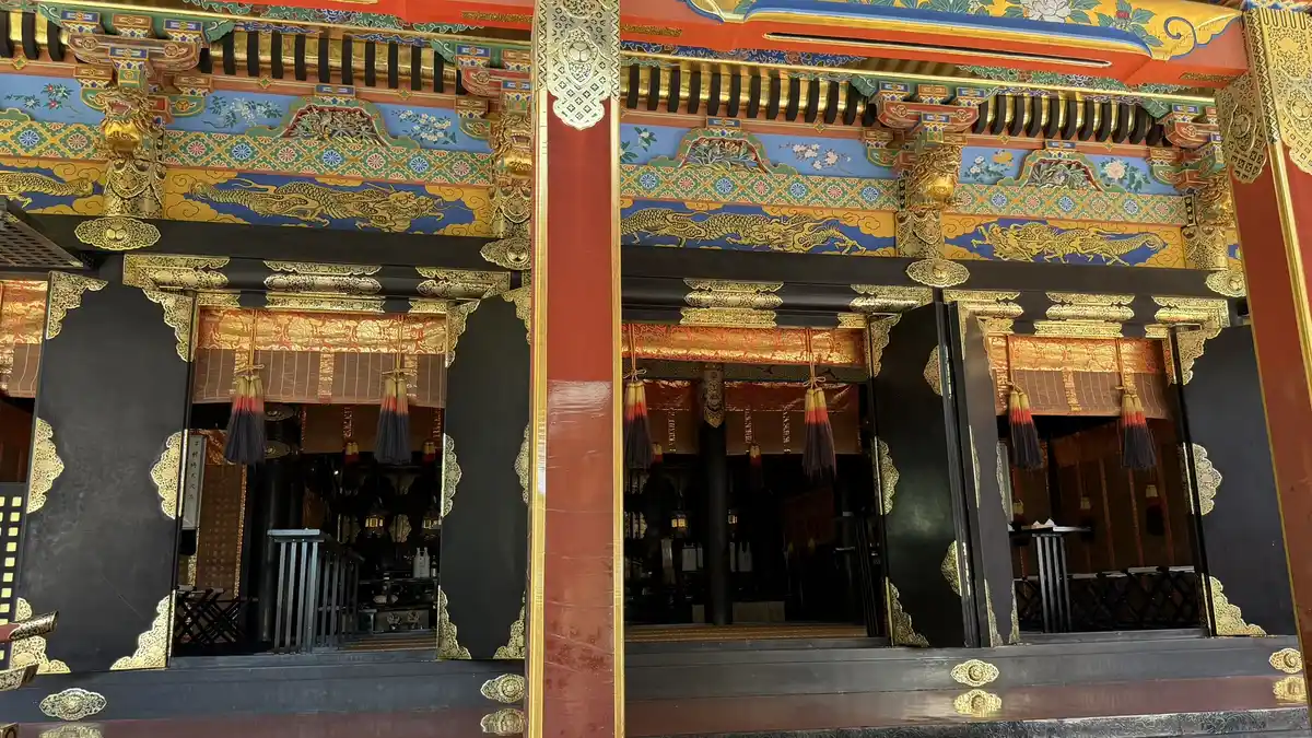 The front of the National Treasure worship hall at Kunozan Toshogu, with black doors and brightly painted decoration under the eaves