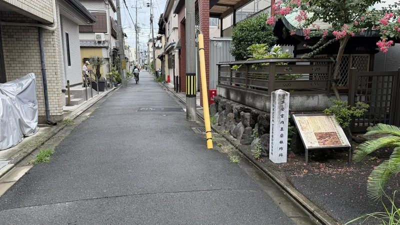 石標が立つ一角と、その前を通る路地