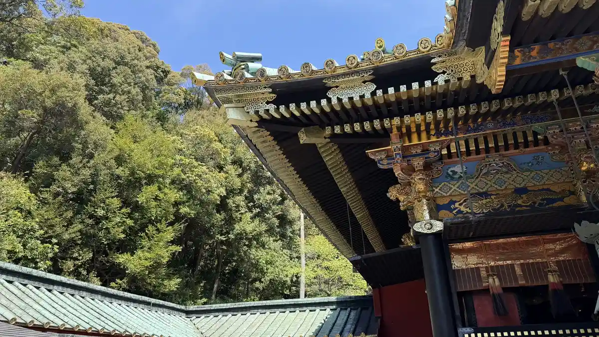 The eaves of the worship hall at Kunozan Toshogu from below, showing brightly painted brackets and the roof edge