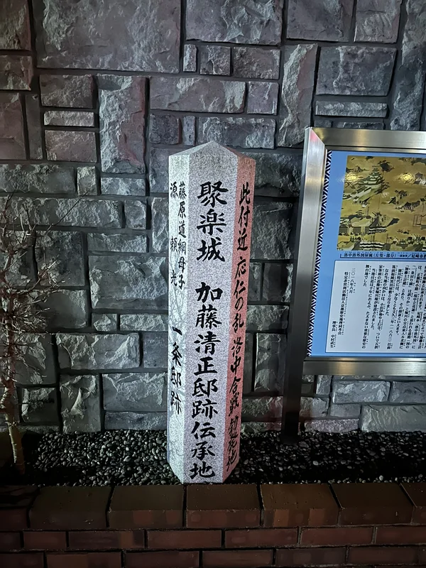 「聚楽城 加藤清正邸跡伝承地」と刻まれた石標。右手に青い解説パネルが並ぶ